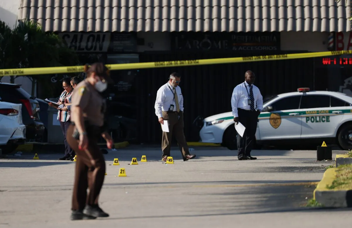 Miami-Dade police investigate near shell case evidence markers on the ground where a mass shooting took place outside of a banquet hall, in Hialeah, Fla., on May 30, 2021. (Joe Raedle/Getty Images)