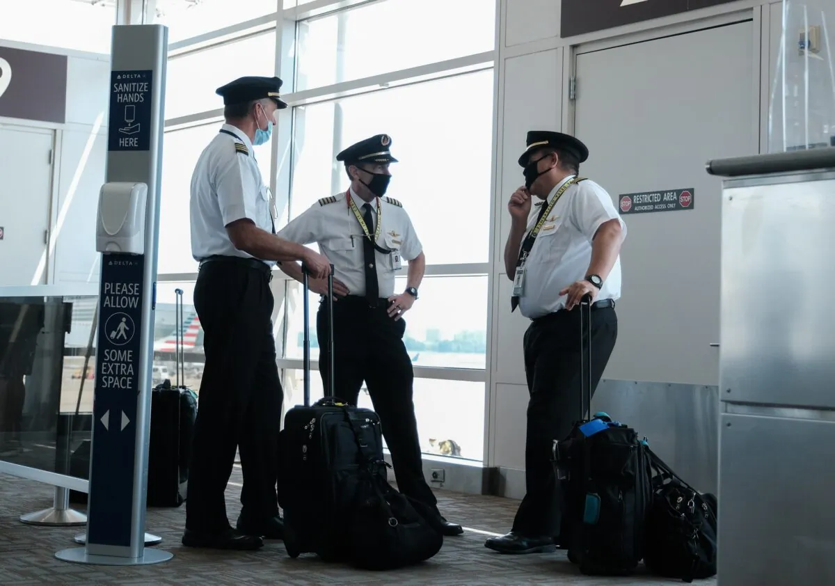 Pilots talk after exiting a Delta Airlines flight at the Ronald Reagan National Airport,  in Arlington, Va., on July 22, 2020. (Michael A. McCoy/Getty Images)