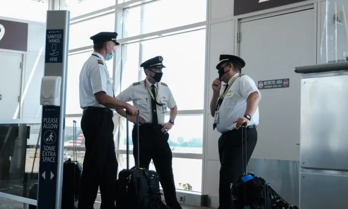 Pilots talk after exiting a Delta Airlines flight at the Ronald Reagan National Airport,  in Arlington, Va., on July 22, 2020. (Michael A. McCoy/Getty Images)