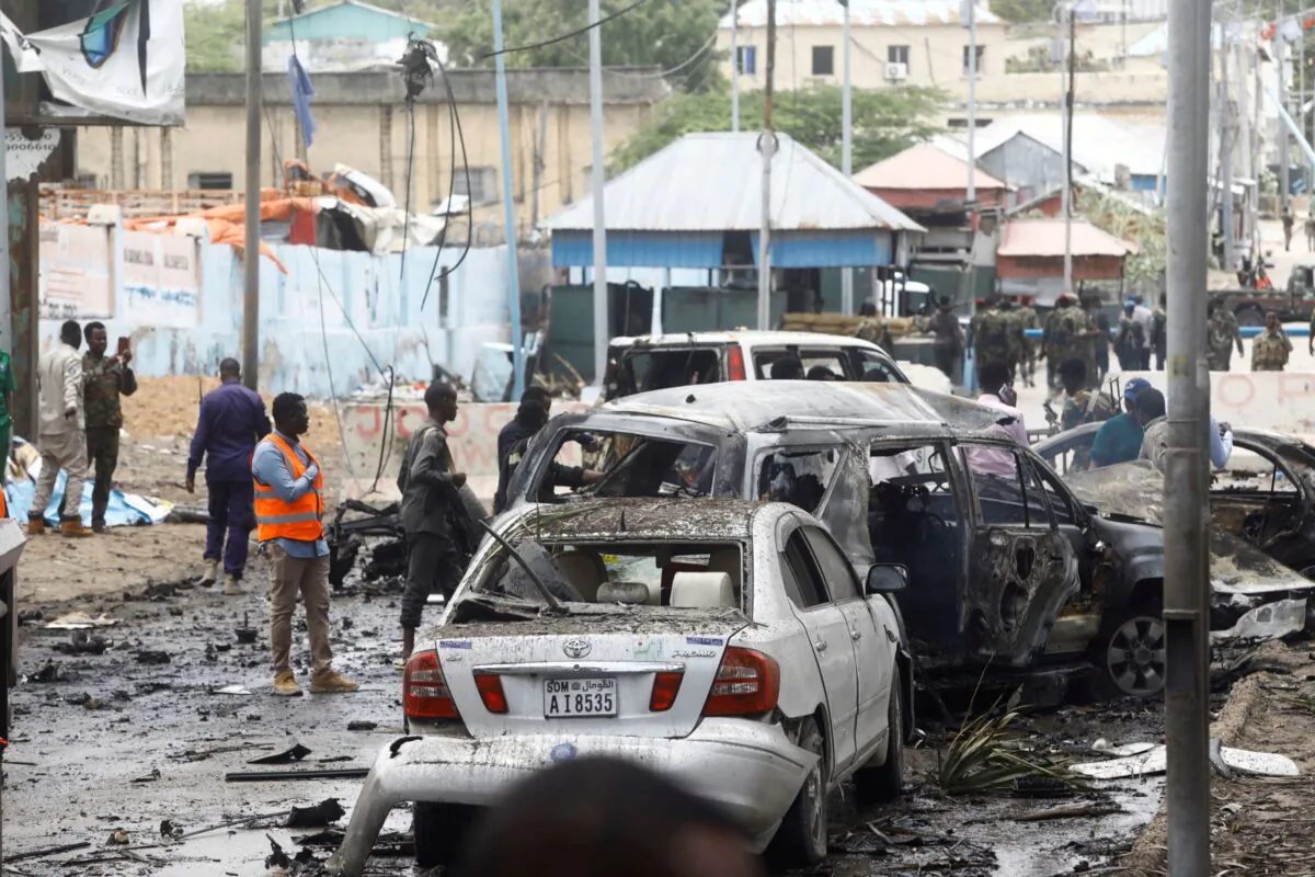 Civilians and Somalian security officers gather at the scene of a suicide car bomb at a street junction near the president's residence, in Mogadishu, Somalia, on Sept. 25, 2021. (Feisal Omar/Reuters)