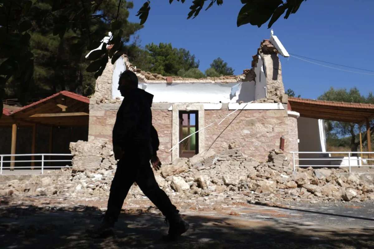 A Resident passes next to a damaged Greek Orthodox chapel after a strong earthquake in Arcalochori village on the southern island of Crete, Greece, on Sept. 27, 2021. (Harry Nikos/AP Photo)