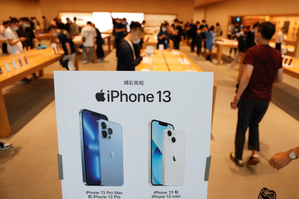 People wearing face masks are pictured at an Apple Store on the day the new Apple iPhone 13 series goes on sale, in Beijing, China, on Sept. 24, 2021. (Carlos Garcia Rawlins/REUTERS)