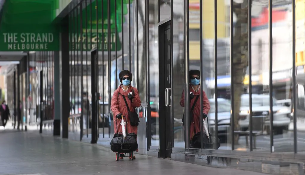 A woman walks along a quiet street in Melbourne's central business district in Australia, on August 11, 2021. (William West/AFP via Getty Images)