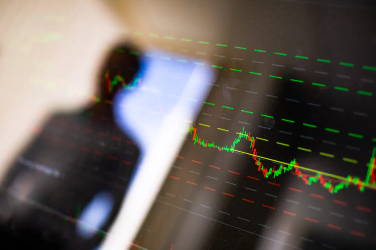 A man looks at a stock market chart in a file photo. (John Fredricks/The Epoch Times)