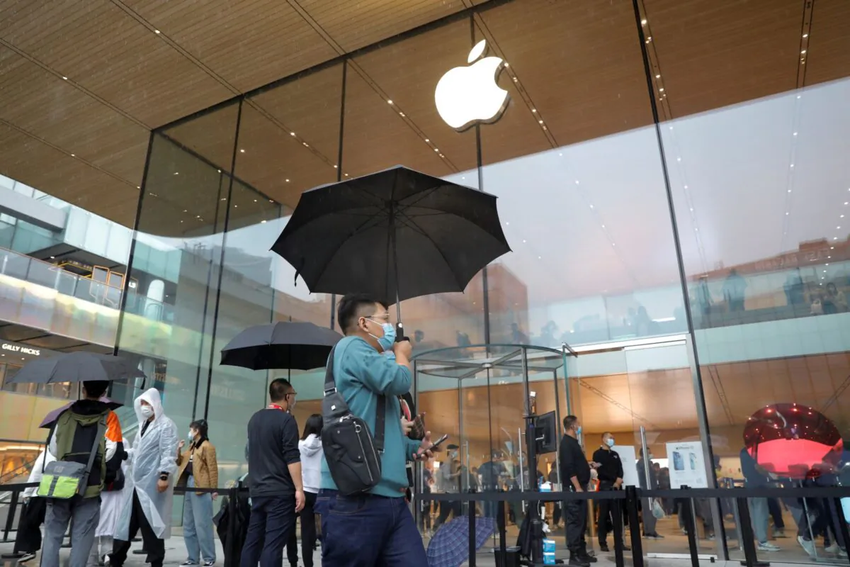 People wearing face masks at an Apple Store on the day the new Apple iPhone 13 series went on sale, in Beijing, China on Sept. 24, 2021. (Carlos Garcia Rawlins/Reuters)