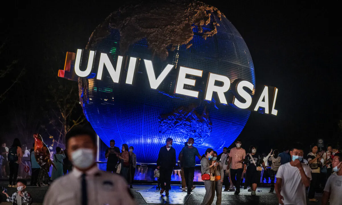 People walk in front of the trademark globe at Universal Studios Beijing city-walk in Beijing, China, on Sept. 23, 2021. (Kevin Frayer/Getty Images)