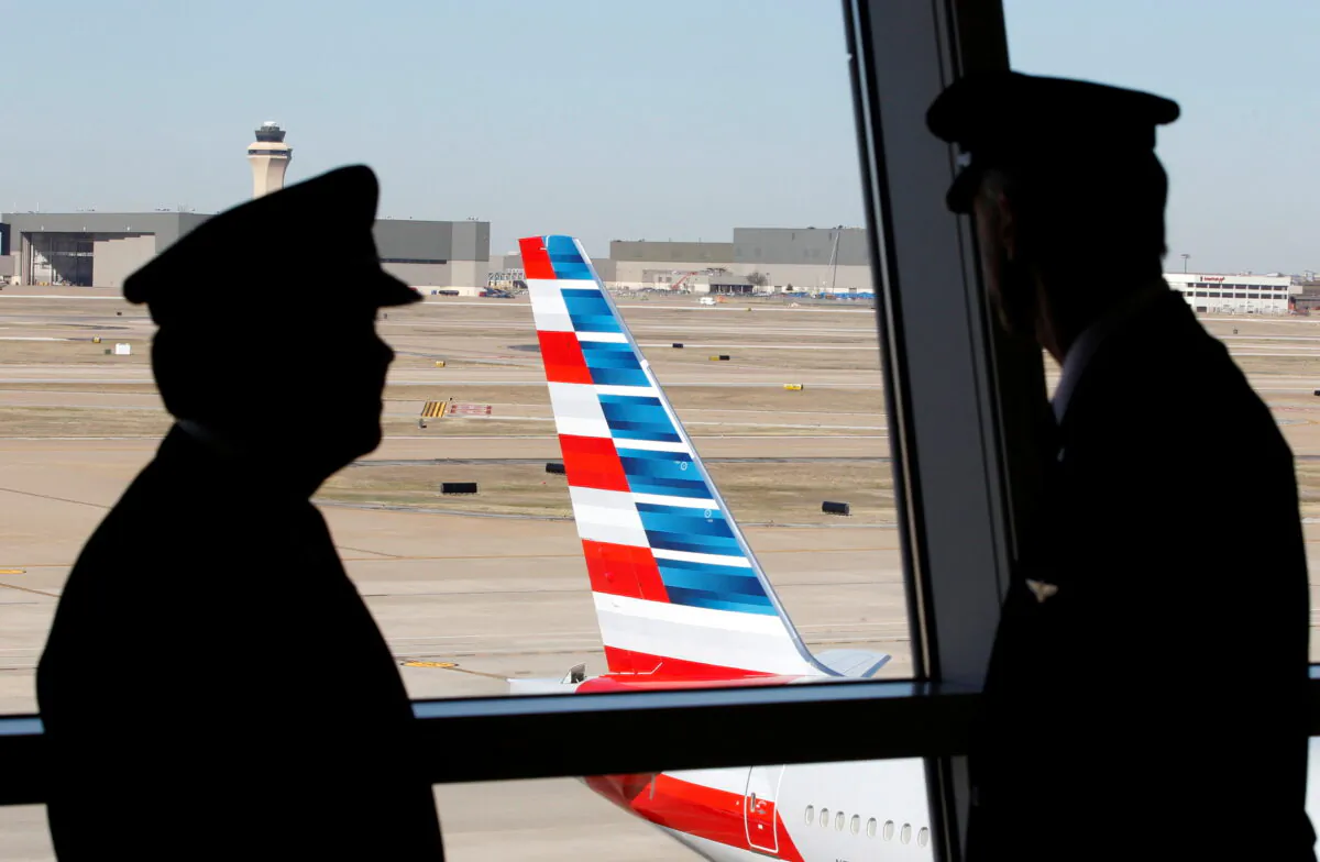 Pilots talk as they look at the tail of an American Airlines aircraft in Dallas, Texas on Feb. 14, 2013. (Mike Stone/file/Reuters)