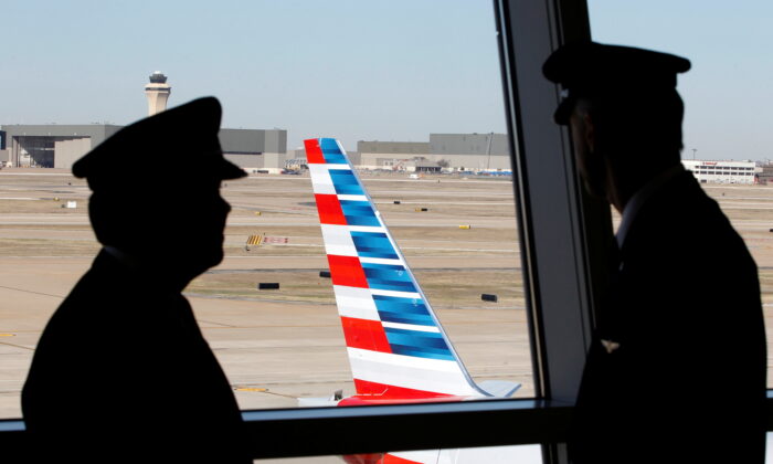 Pilots talk as they look at the tail of an American Airlines aircraft in Dallas, Texas on Feb. 14, 2013. (Mike Stone/file/Reuters)