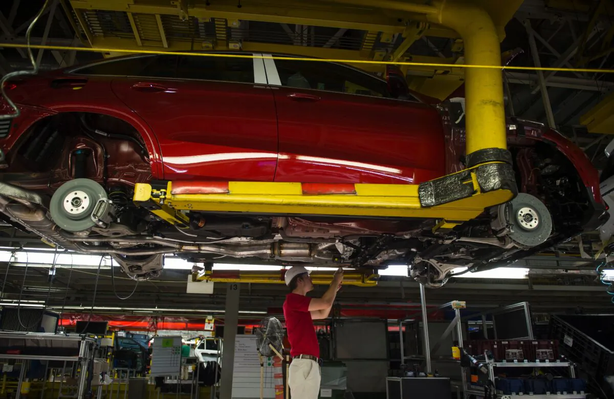 An employee installs parts on the undercarriage of a Mercedes-Benz GLS-Class SUV at the Mercedes-Benz US International factory in Vance, Alabama on June 8, 2017. (ANDREW CABALLERO-REYNOLDS/AFP via Getty Images)