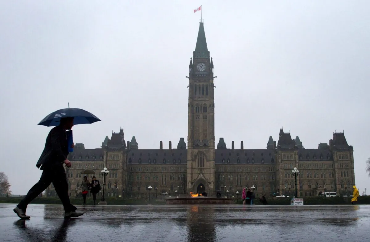 Pedestrians make their way across Parliament Hill in Ottawa in a file photo. (The Canadian Press/Sean Kilpatrick)