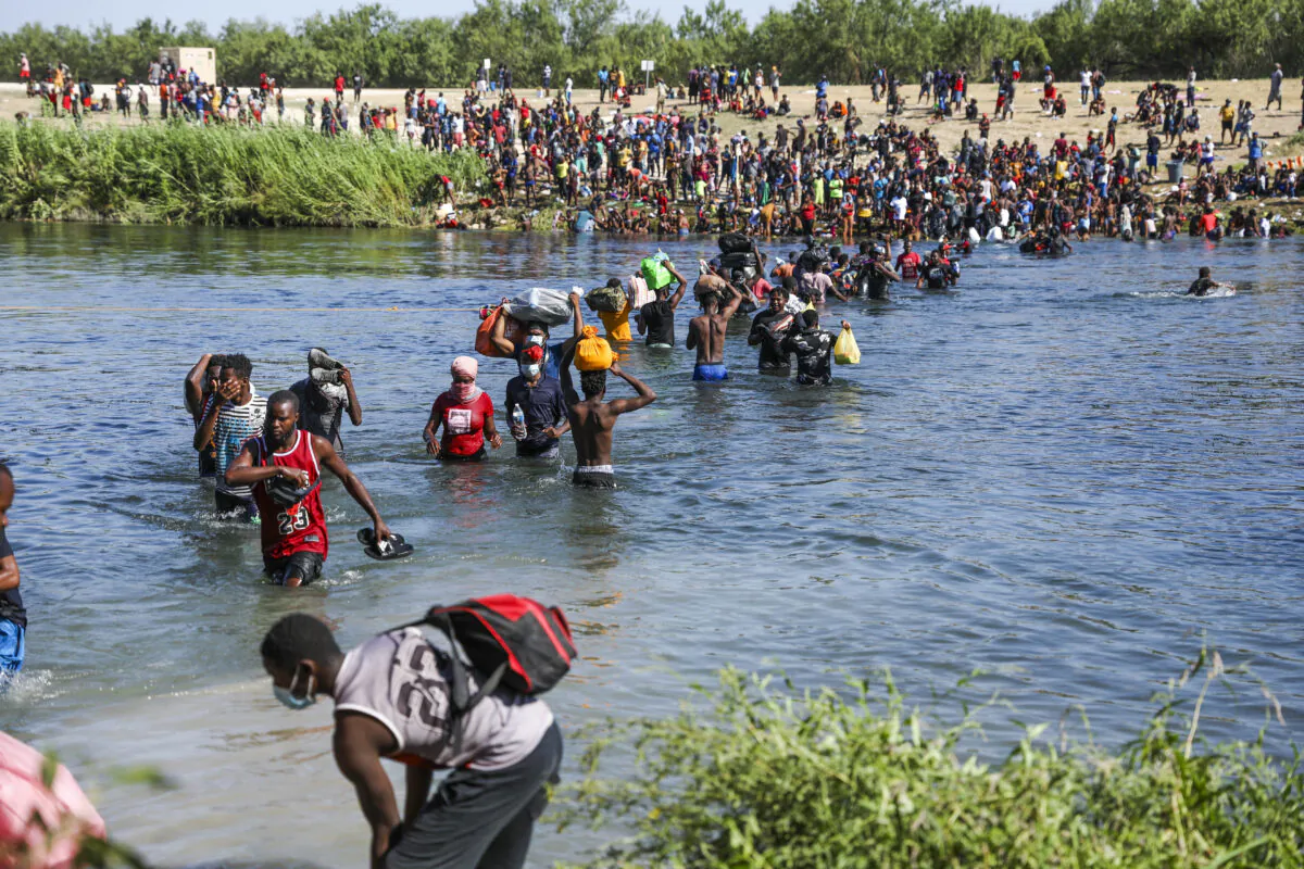 Illegal immigrants take supplies back and forth between Acuña, Mexico, and the United States (far side) across the Rio Grande, the international boundary with Mexico, in Acuña, Mexico, on Sept. 20, 2021. (Charlotte Cuthbertson/The Epoch Times)