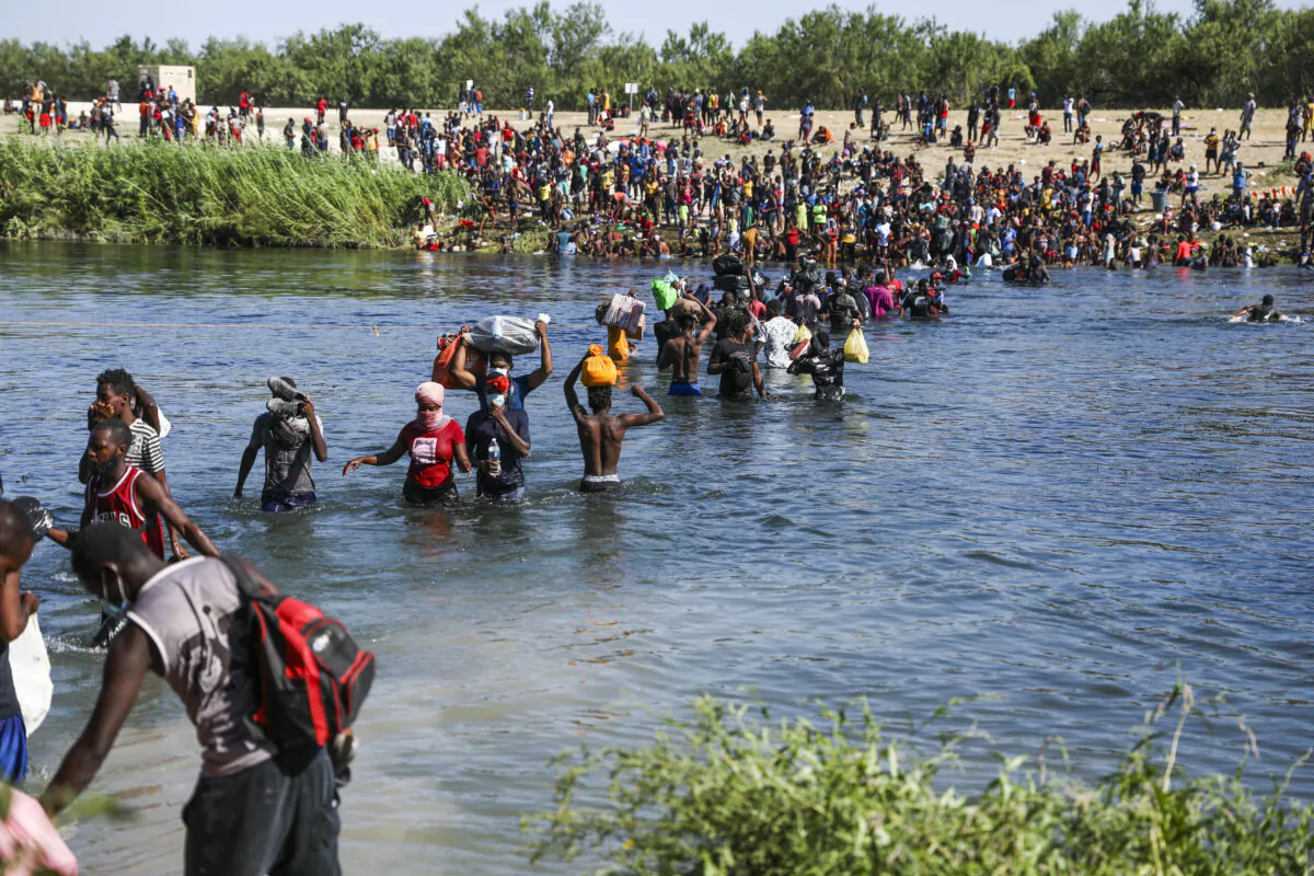 Illegal immigrants take supplies back and forth between Acuña, Mexico, and the United States (far side) across the Rio Grande, the international boundary with Mexico, in Acuña, Mexico, on Sept. 20, 2021. (Charlotte Cuthbertson/The Epoch Times)