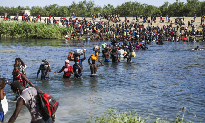 Illegal immigrants take supplies back and forth between Acuña, Mexico, and the United States (far side) across the Rio Grande, the international boundary with Mexico, in Acuña, Mexico, on Sept. 20, 2021. (Charlotte Cuthbertson/The Epoch Times)