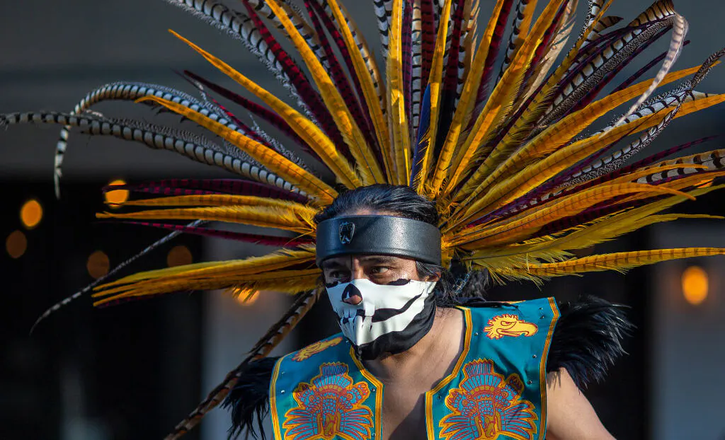 An Aztec dancer participates in a march in Los Angeles, on May 1, 2019. (David McNew/Getty Images)