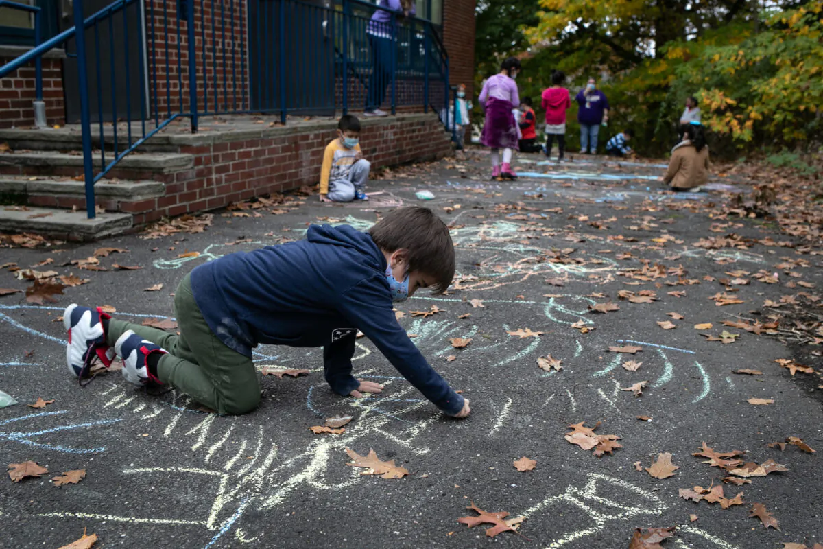 A first grader draws during recess at Stark Elementary School in Stamford, Conn., on Oct. 21, 2020. (John Moore/Getty Images)