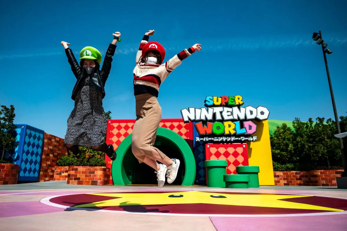Fans of Universal Studio Japan pose at the entrance of the Super Nintendo World, during a media preview of the theme park in Osaka, Japan, on March 17, 2021. (Philip Fong/AFP via Getty Images)