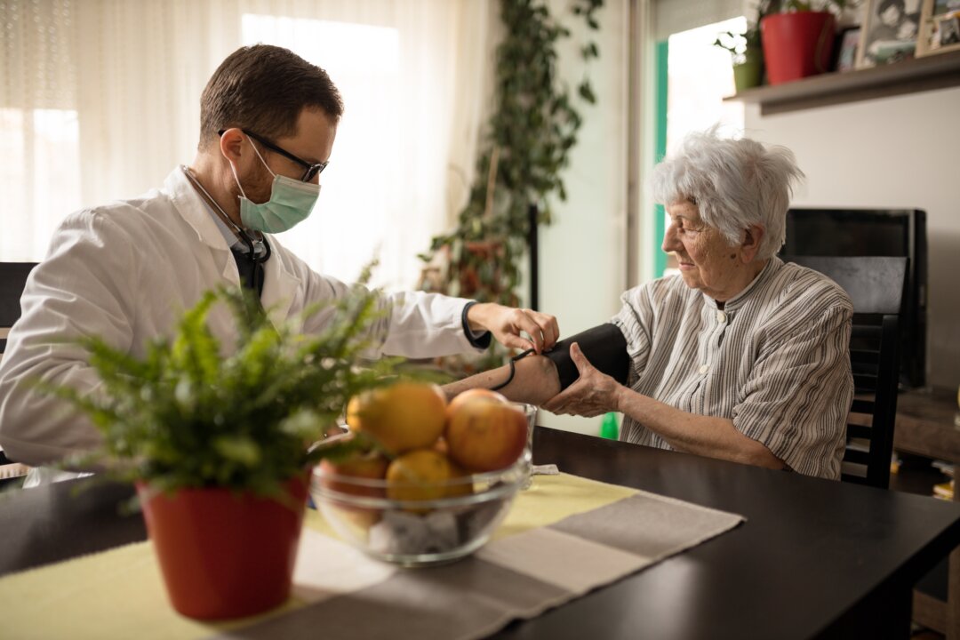 A doctor checks the blood pressure of a patient. (Gligatron/Shutterstock)