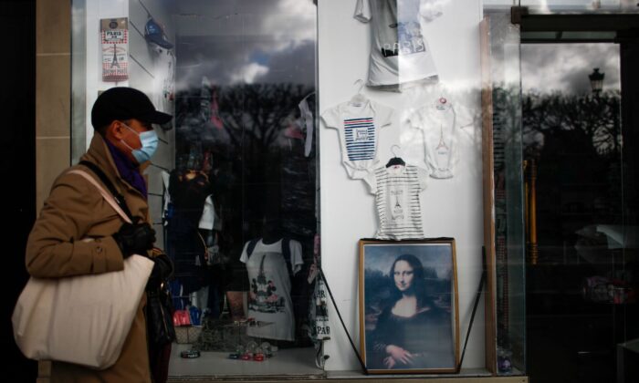 A man wearing a protective face mask "Mona Lisa" (La Joconde) A poster posted at a closed tourist souvenir shop in the arcade of Rue de Rivoli in Paris during the outbreak of coronavirus disease (COVID-19) in France on January 29, 2021.  (Gonzalo Fentes / Reuters)