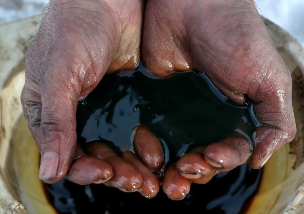 An employee holds a sample of crude oil at the Yarakta oilfield, owned by Irkutsk Oil Co, in the Irkutsk region, Russia on March 11, 2019. (Vasily Fedosenko/Reuters)