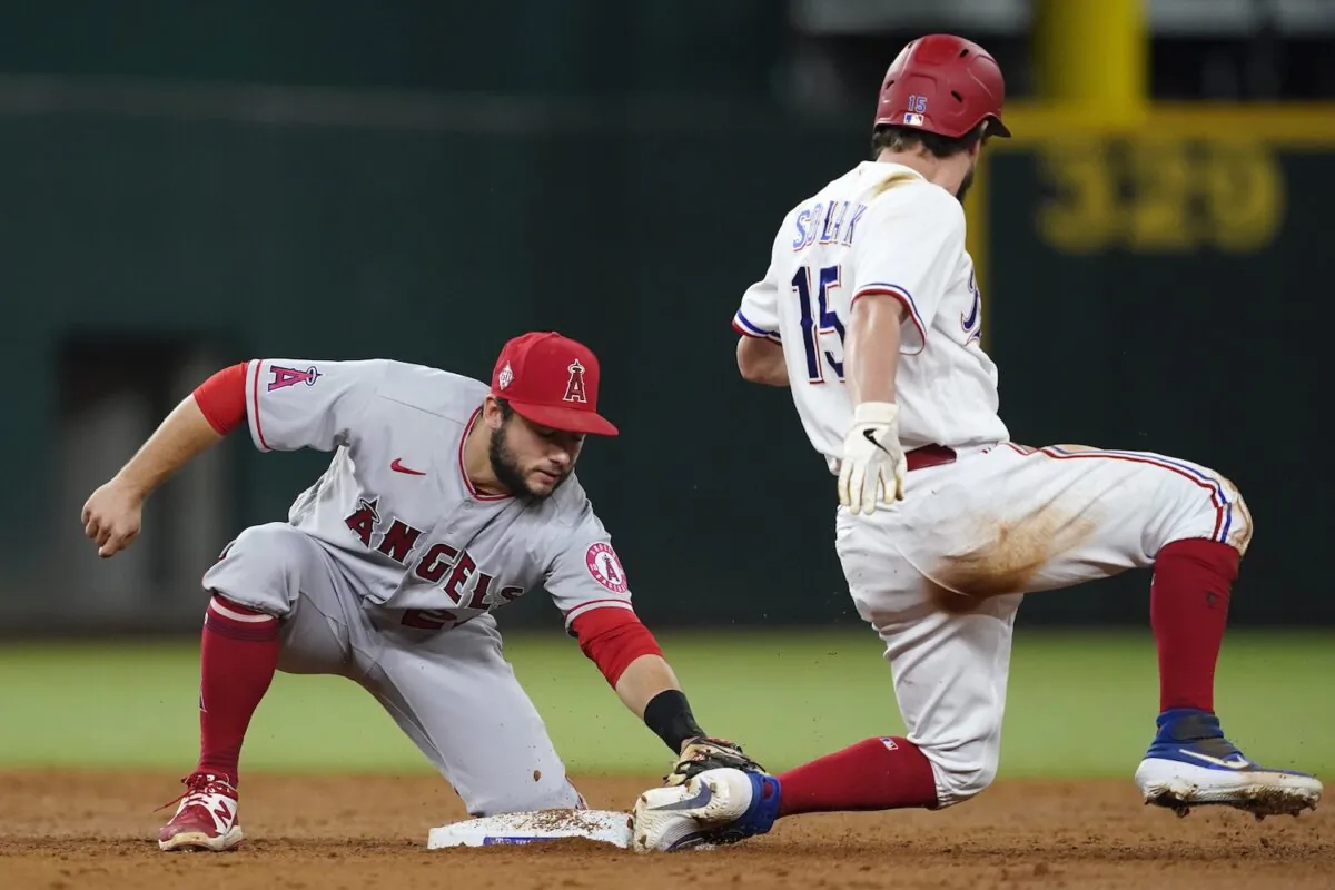 Los Angeles Angels second baseman David Fletcher (22) tags out Texas Rangers' Nick Solak (15) who was attempting to steal the bag in the third inning of a baseball game in Arlington, Texas on Sept. 28, 2021. (AP Photo/Tony Gutierrez)