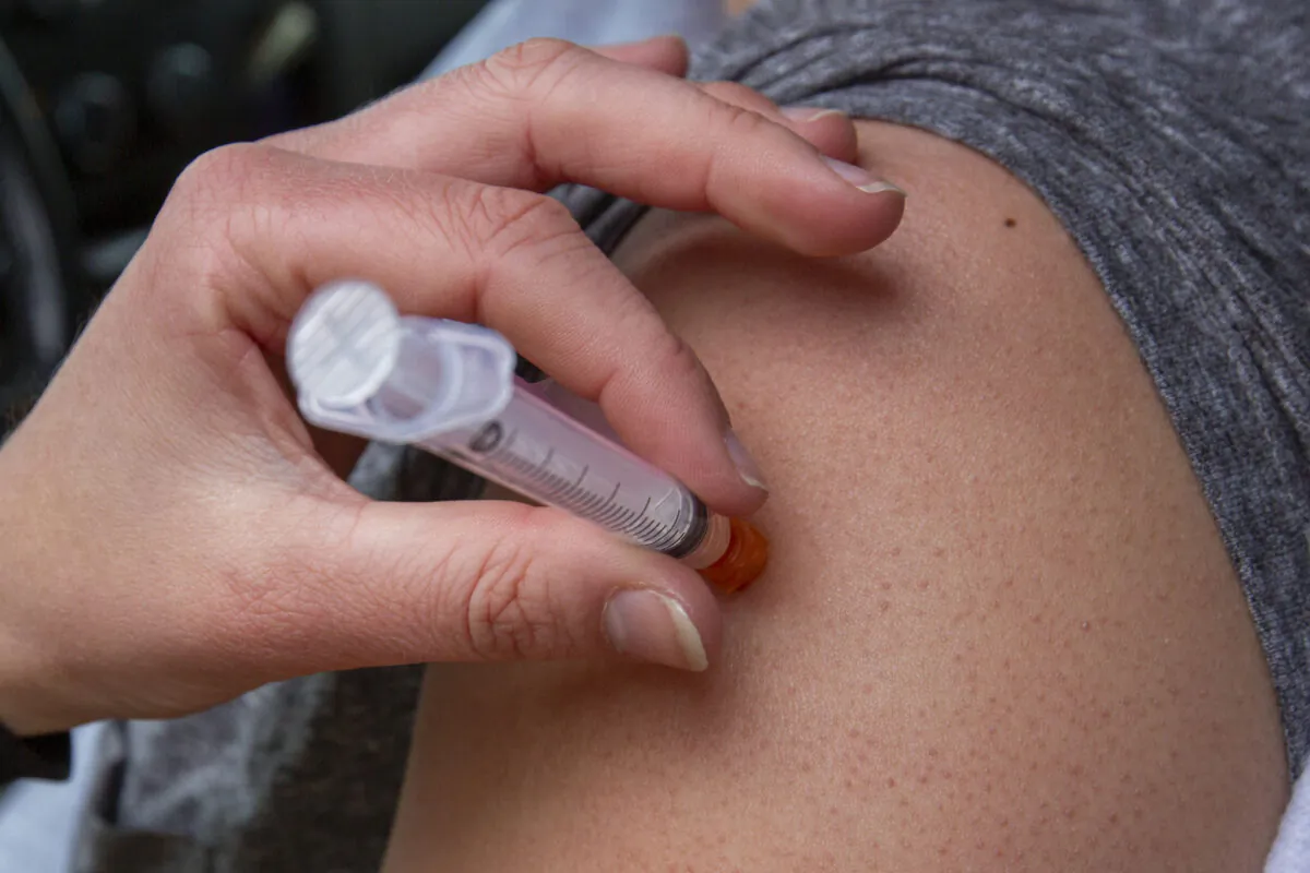 A person receives a COVID-19 vaccine at a drive-thru clinic at Richardson Stadium in Kingston, Ont., on May 28, 2021. (The Canadian Press/Lars Hagberg)