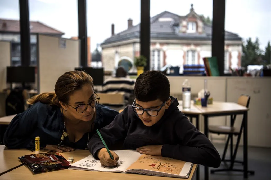 A teacher and an autistic child work on lessons together, at the College du Parc in Aulnay-sous-Bois, France, on Oct. 9, 2019. 

 CHRISTOPHE ARCHAMBAULT/AFP via Getty Images