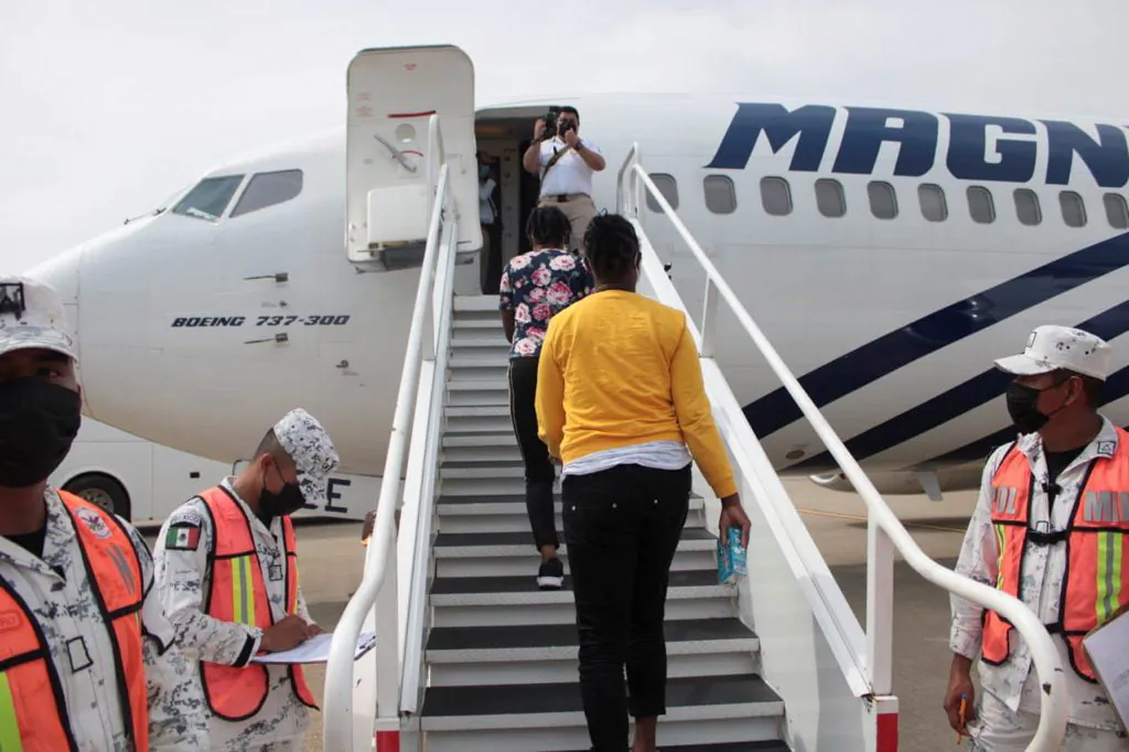 Haitian migrants board a plane as part of the "assisted voluntary return" to Haiti by Mexican authorities, at the Carlos Rovirosa Perez International airport, in Villahermosa, Mexico, on Sept. 29, 2021. (Mexico's National Migration Institute/Reuters)