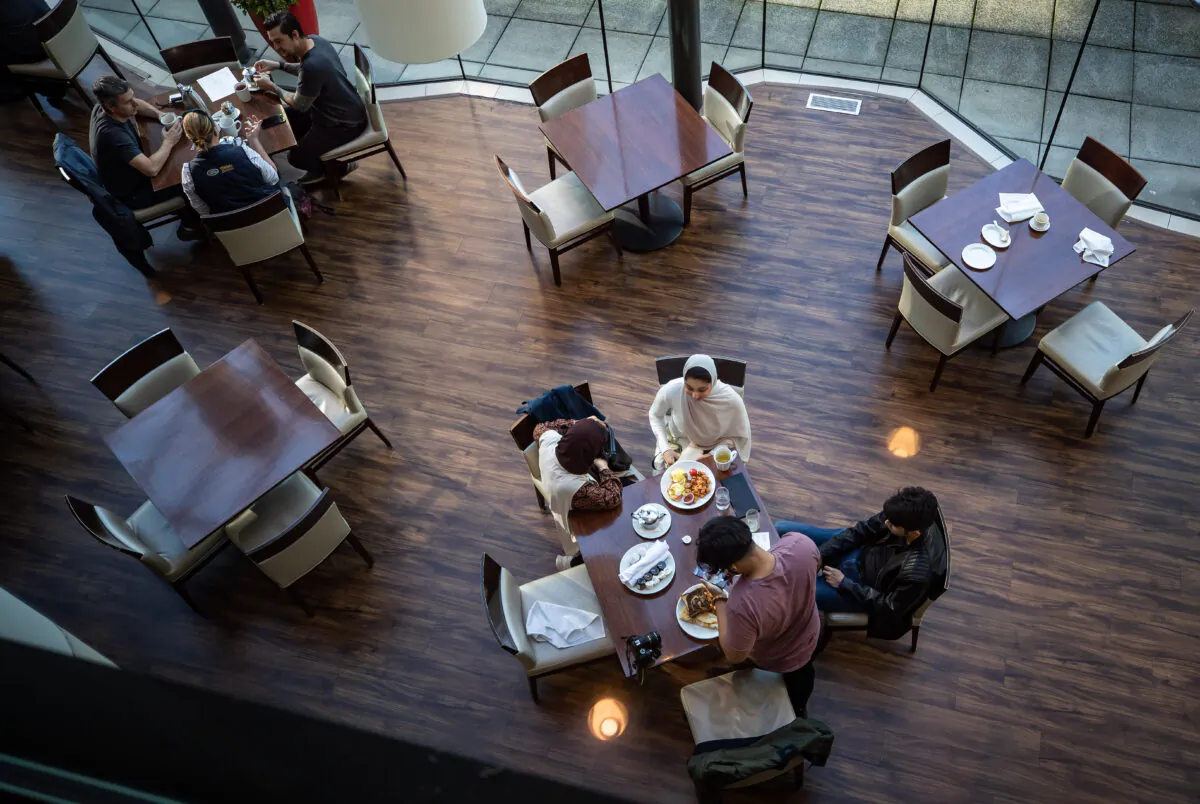 A server brings food to a table as people dine at a restaurant in Vancouver, on Sept. 21, 2021. British Columbia's COVID-19 vaccine card system went into effect last week. Anyone who wants access to a range of non-essential indoor services, including restaurants, must show proof of at least one dose of vaccine, with a second shot required by Oct. 24. (The Canadian Press/Darryl Dyck)