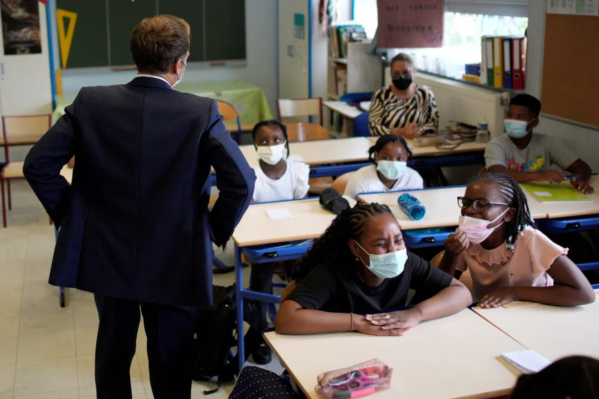 French President Emmanuel Macron speaks with students during a visit at Bouge primary school in Malpasse district of Marseille, France, on Sept. 2, 2021. (Daniel Cole/Pool via Reuters)