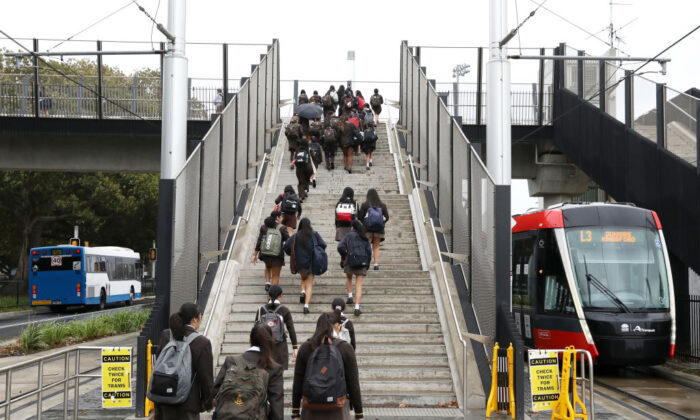 Students walk up the stairs of the overpass at the Sydney Light Rail Moore Park stop on their way to school in Sydney, Australia, on May 25, 2020. (Mark Kolbe/Getty Images)