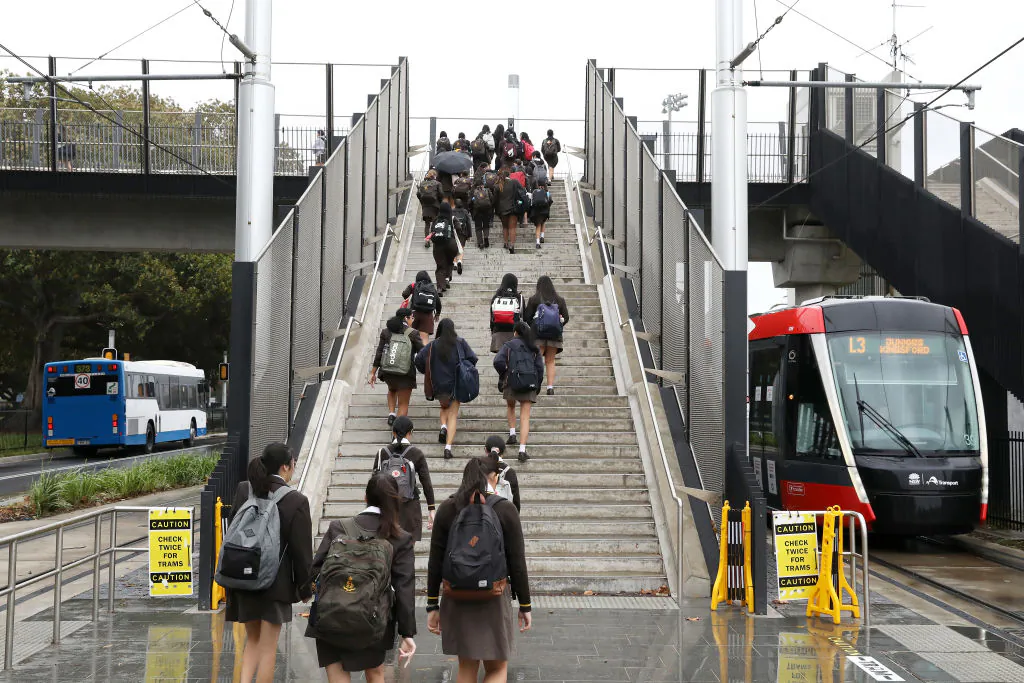 Students walk up the stairs of the overpass at the Sydney Light Rail Moore Park stop on their way to school in Sydney, Australia, on May 25, 2020. (Mark Kolbe/Getty Images)