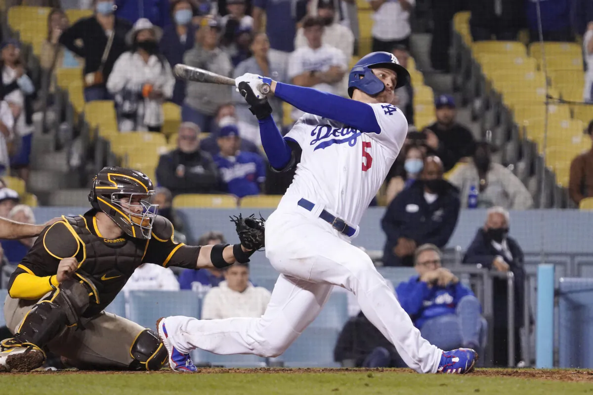 Los Angeles Dodgers' Corey Seager, right, hits a two-run home run as San Diego Padres catcher Victor Caratini watches during the eighth inning of a baseball game in Los Angeles on Sept. 29, 2021. (AP Photo/Mark J. Terrill)