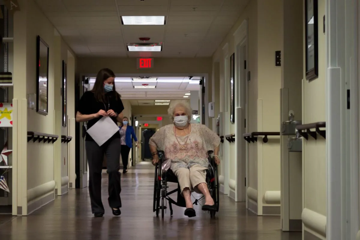 Care giver walks with nursing home resident at a Quality Life Services facility in western Pennsylvania. (Courtesy of the Pennsylvania Health Care Association)