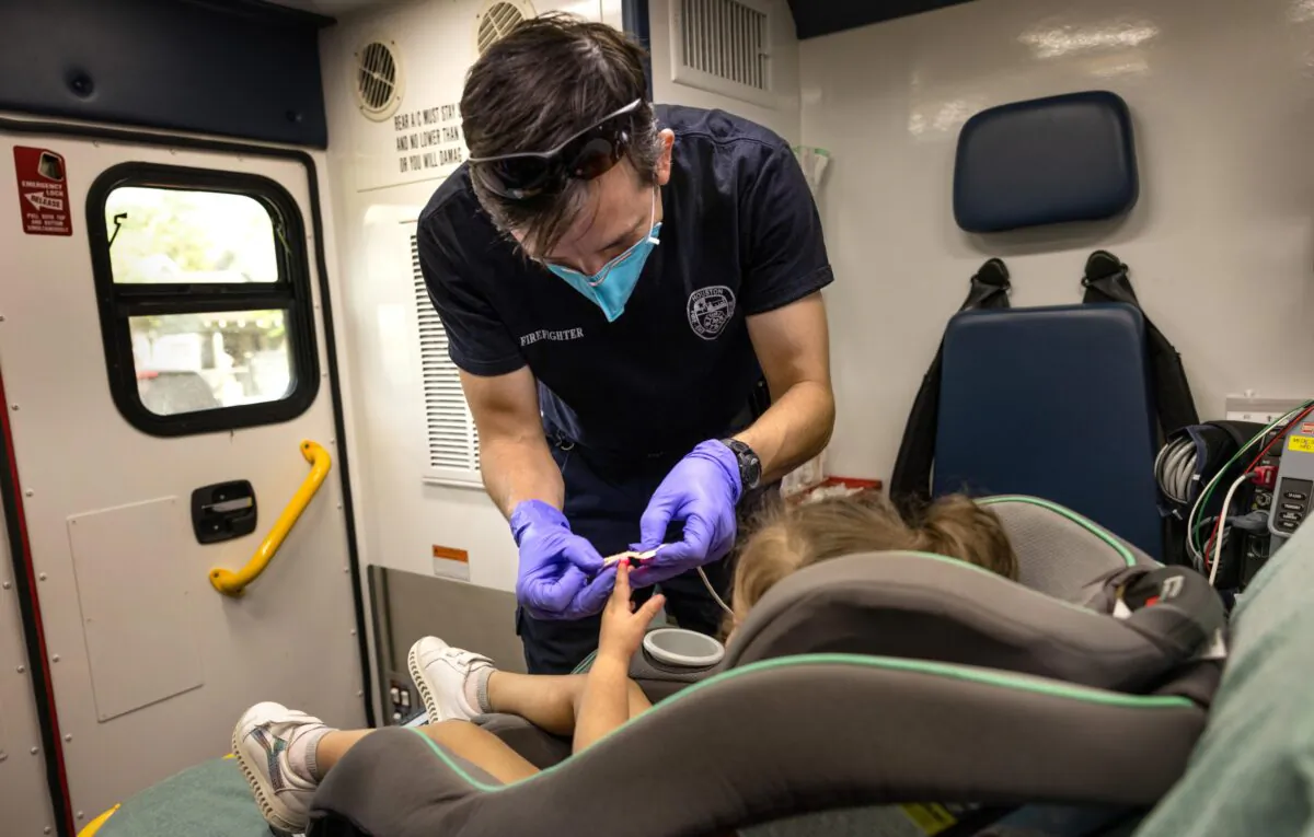 An EMS medic from the Houston Fire Department prepares to transport a Covid-19 positive girl, age 2, to a hospital, in Houston, Texas, on Aug. 25, 2021. (John Moore/Getty Images)