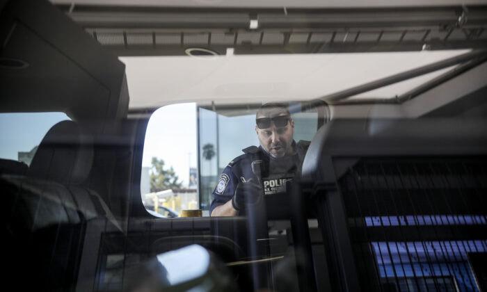 An Immigration and Customs Enforcement (ICE) agent checks an automobile at the U.S.-Mexico border. (File Photo/Sandy Huffaker/AFP via Getty Images)