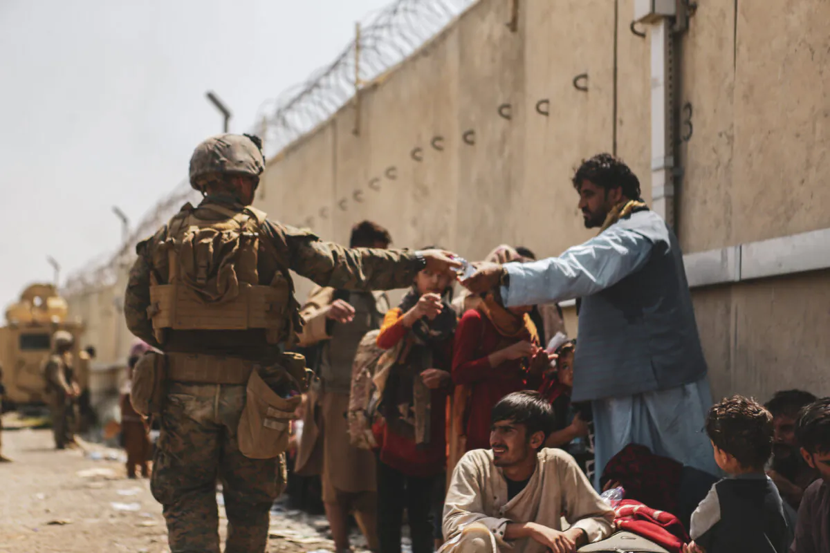 A Marine with the 24th Marine Expeditionary Unit passes out water to Afghan evacuees at Hamid Karzai International Airport in Kabul, Afghanistan on Aug. 22, 2021. (Sgt. Isaiah Campbell/U.S. Marine Corps via Getty Images)