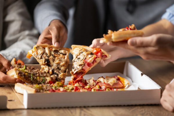 Close,Up,Of,Multiethnic,Young,People,Gather,In,Pizzeria,Together
