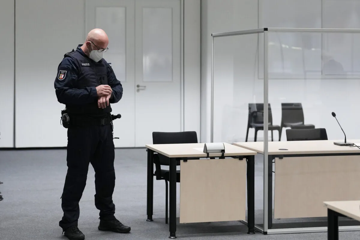 A judicial officer looks at his watch prior of a trail against a 96-year-old former secretary for the SS commander of the Stutthof concentration at the court room in Itzehoe, Germany, on Sept. 30, 2021. (Markus Schreiber/AP Photo)