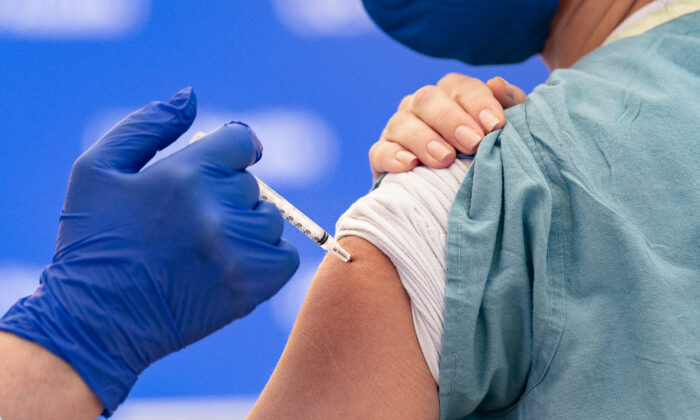 A nurse recieves a COVID-19 vaccination at UCI Medical Center in Orange, Calif., on Dec. 16, 2020. (John Fredricks/  Pezou)