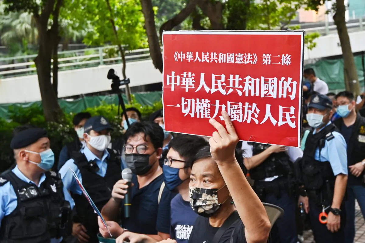 Pro-democracy activists carrying a placard during a protest in the Wan Chai district in Hong Kong, on October 1, 2021. (Sung Pi-lung/The Epoch Times)