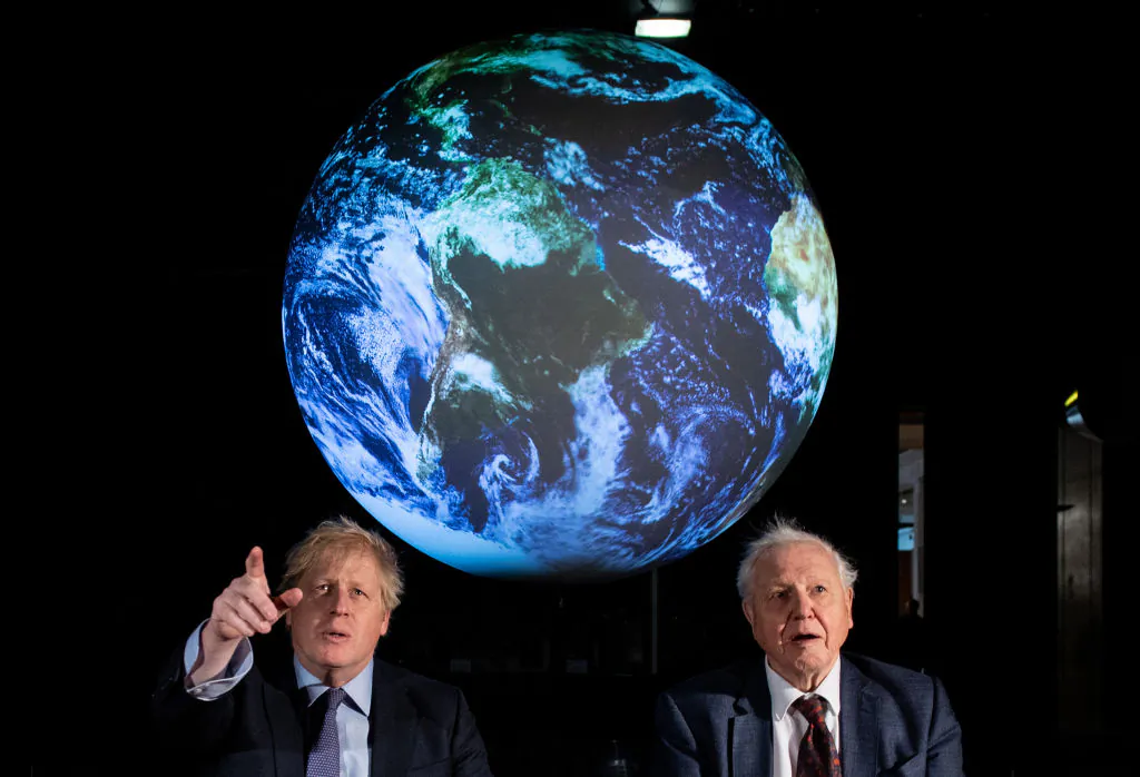 British Prime Minister Boris Johnson (L) and British broadcaster David Attenborough speak with school children during the launch of the UK-hosted COP26 U.N. Climate Summit, which will take place this autumn in Glasgow, at the Science Museum in London, England, on Feb. 4, 2020. (Chris J. Ratcliffe/WPA Pool/Getty Images)
