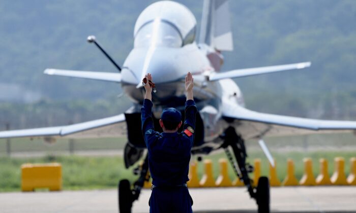 A military personnel guides a Chengdu Aircraft Corporation's J-10 for the People's Liberation Army Air Force (PLAAF) after its flight demonstration program at the 13th China International Aviation and Aerospace Exhibition in Zhuhai, in southern China's Guangdong Province on Sept. 28, 2021. (Noel Celis/AFP via Getty Images)