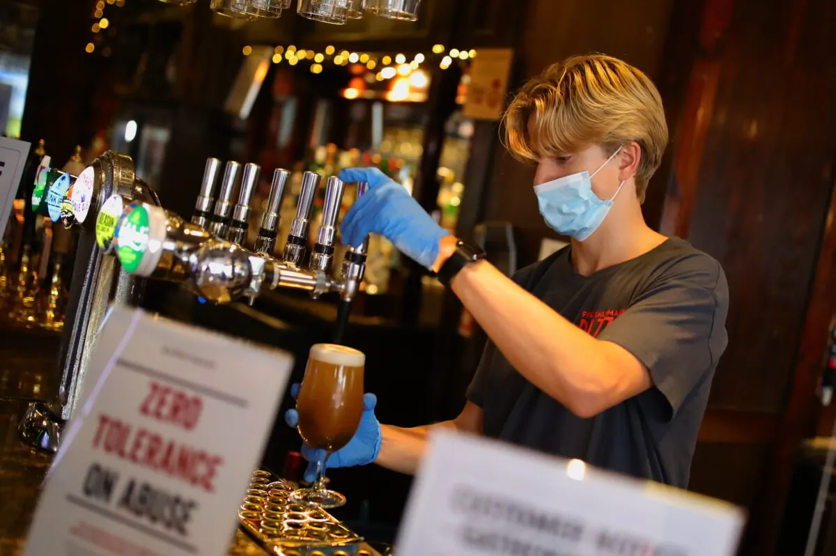 Bar staff pour drinks at The Toll Gate, a Wetherspoons pub in Hornsey, north London, on July 4, 2020. (Aaron Chown/PA Media)