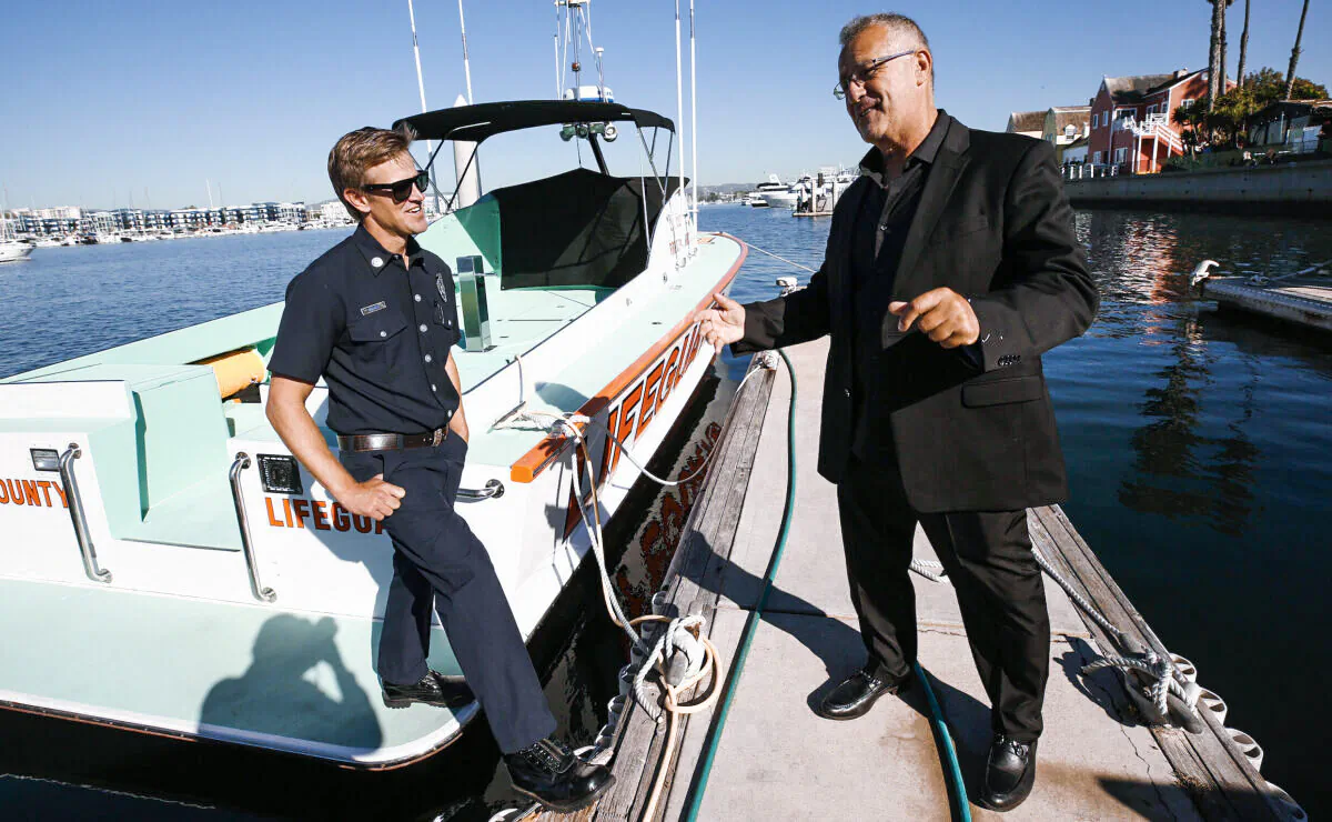 Civilian boat captain Khosrow “Koz” Khosravani (R) greets Los Angeles County Fire Department Ocean Lifeguard Capt. Matt Rhodes at Los Angeles County’s Harbor Patrol in Marina del Rey a month after the two men saved a woman from the open waters of the Pacific Ocean, in Los Angeles, on Oct. 28, 2021. (Al Seib/Los Angeles Times/TNS)
