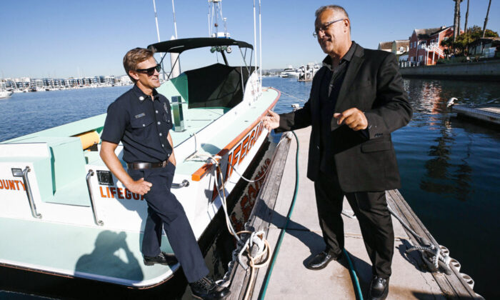 Civilian boat captain Khosrow “Koz” Khosravani (R) greets Los Angeles County Fire Department Ocean Lifeguard Capt. Matt Rhodes at Los Angeles County’s Harbor Patrol in Marina del Rey a month after the two men saved a woman from the open waters of the Pacific Ocean, in Los Angeles, on Oct. 28, 2021. (Al Seib/Los Angeles Pezou/TNS)