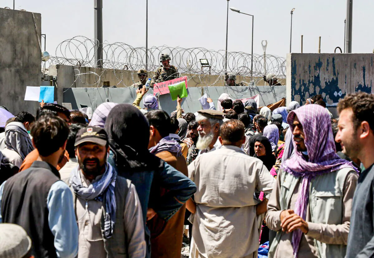 Crowds of people show their documents to U.S. troops outside the airport in Kabul, Afghanistan, on Aug. 26, 2021. (Stringer/Reuters)