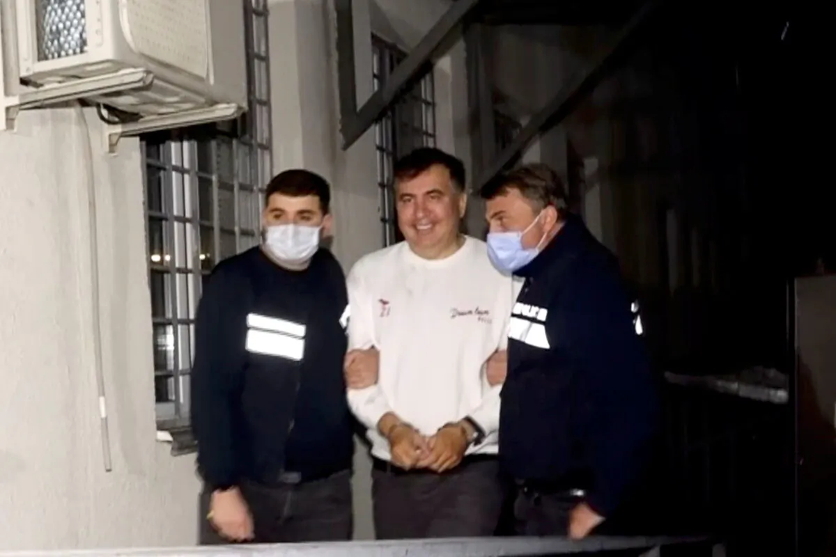 Georgia's former President Mikheil Saakashvili, who was detained after returning to the country, is escorted by police officers as he arrives at a prison in Rustavi, Georgia, on Oct. 1, 2021. (Georgian Interior Ministry/Handout via Reuters)
