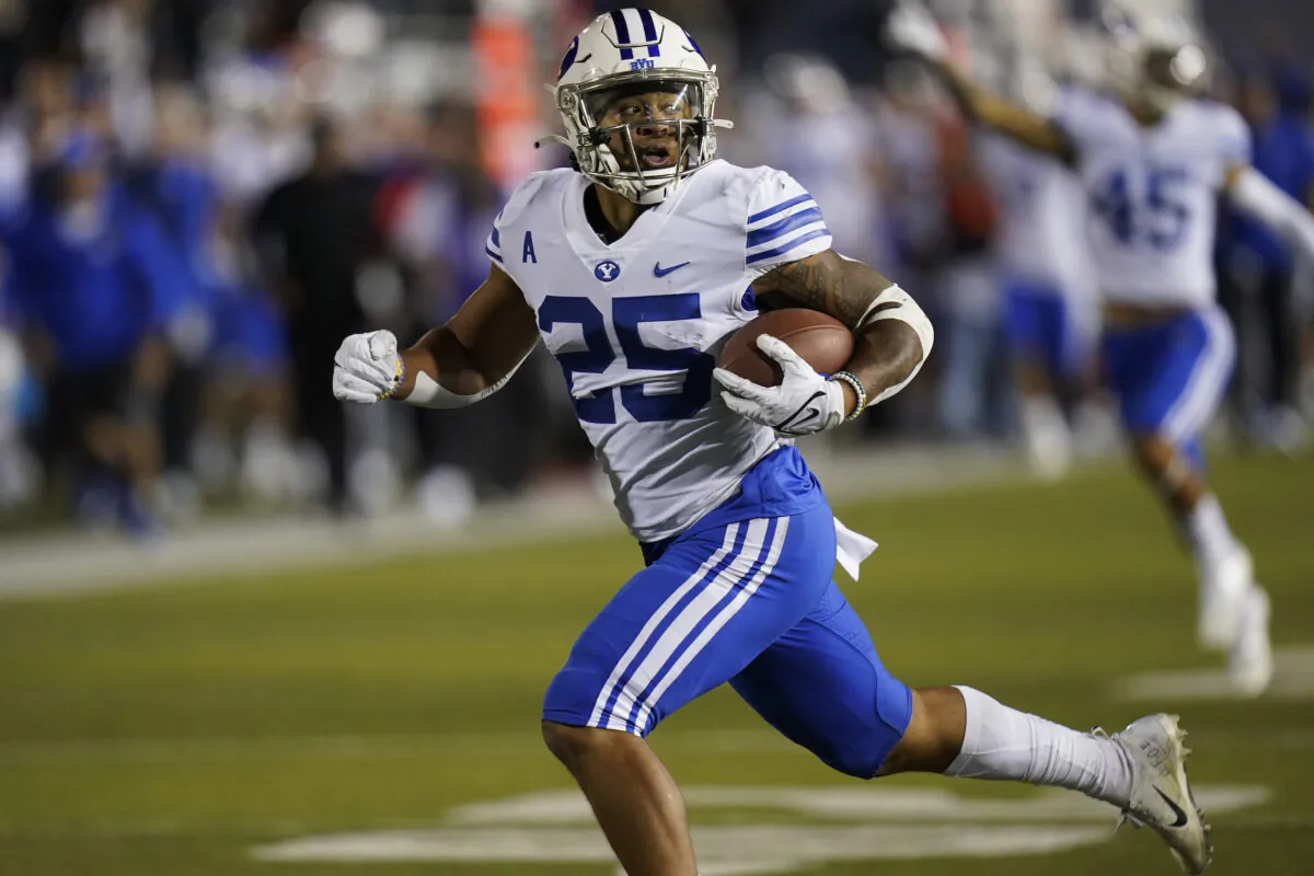 BYU's Tyler Allgeier (25) carries the ball before scoring against Utah State in the first half during an NCAA college football game in Logan, Utah, on Oct. 1, 2021, (Rick Bowmer/AP Photo)