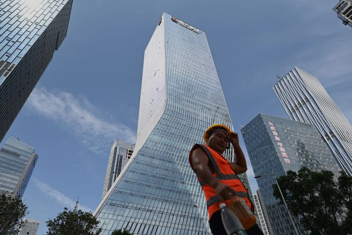 A worker walks in front of Evergrande headquarters in Shenzhen, China, on Sept. 26, 2021. (Noel Celis/AFP via Getty Images)