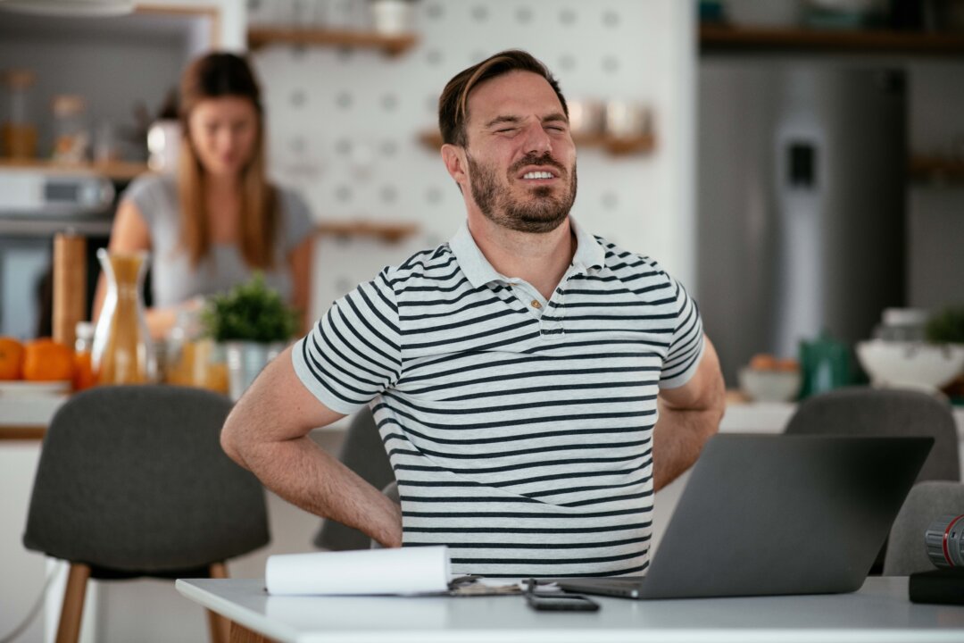Sitting at your computer and looking down at your phone often lead to slouching and slouching takes a toll. (Just Life/Shutterstock)